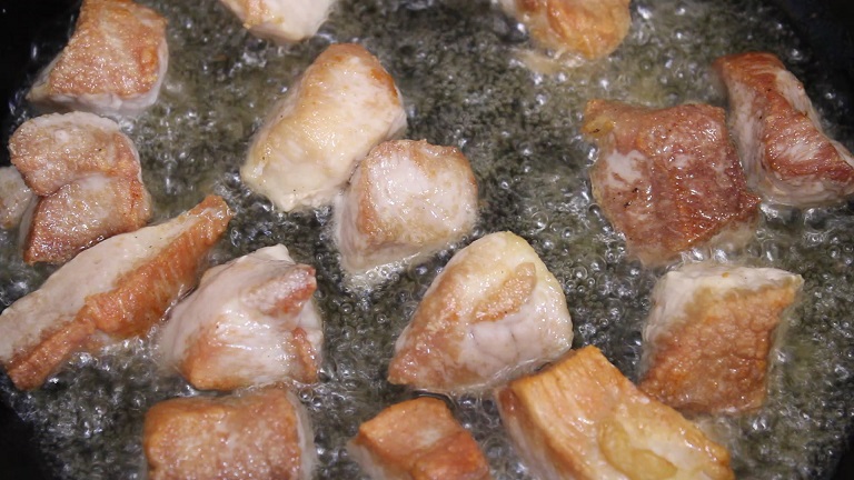 кусочки свинины жаряться на сковороде в масле